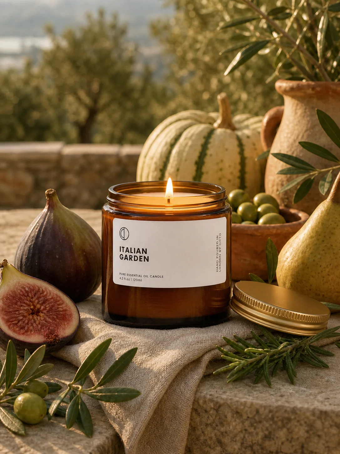 Lit Italian Garden candle staged with figs, olives, and autumn harvest elements