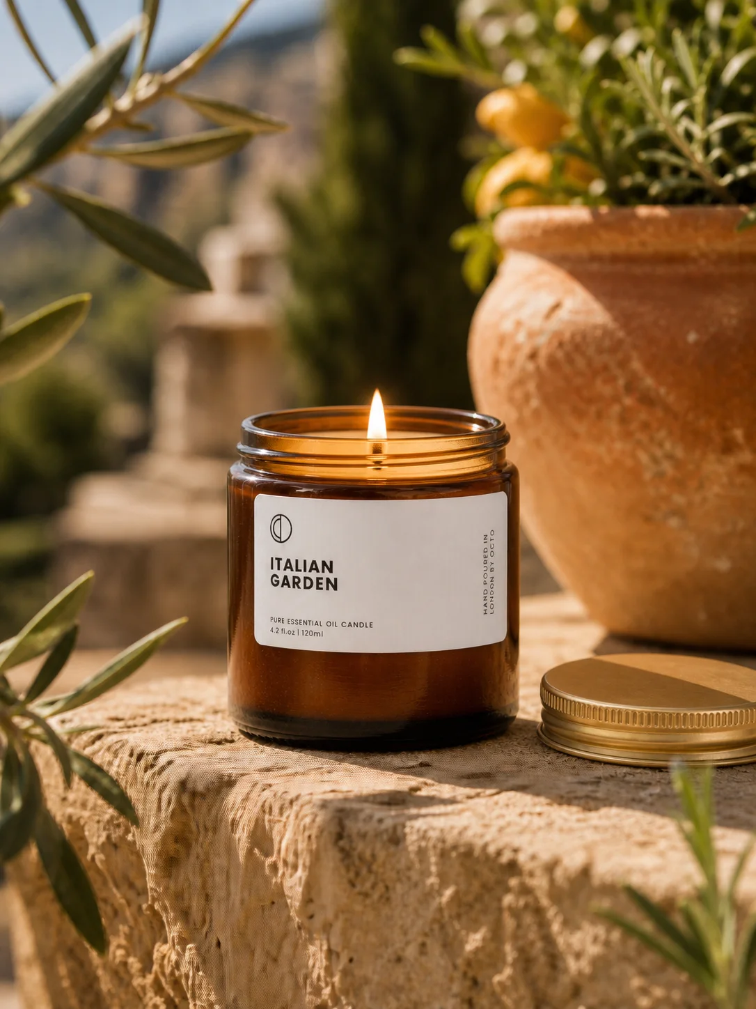 Lit Italian Garden candle staged on a Mediterranean garden terrace